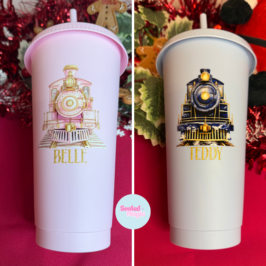Two tumblers with train designs and names 'Belle' and 'Teddy' on a red background.